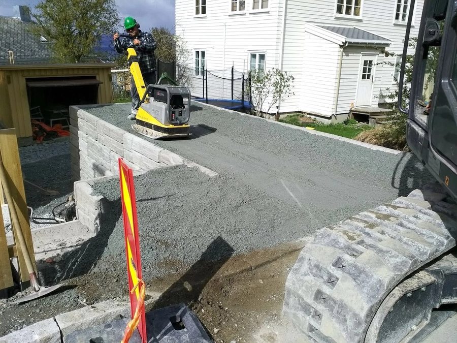 Komprimering av bærelag foran hvitt hus