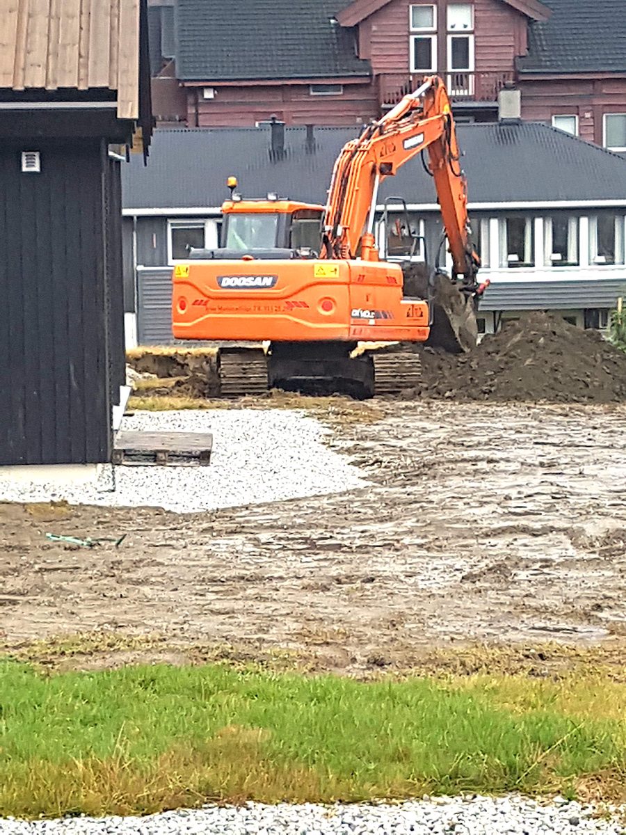 Gravemaskin planerer tomt ved nybygd bolig